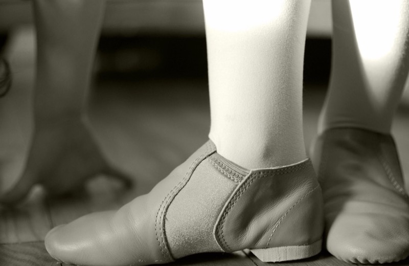 Tan slip-on jazz shoes worn with tights